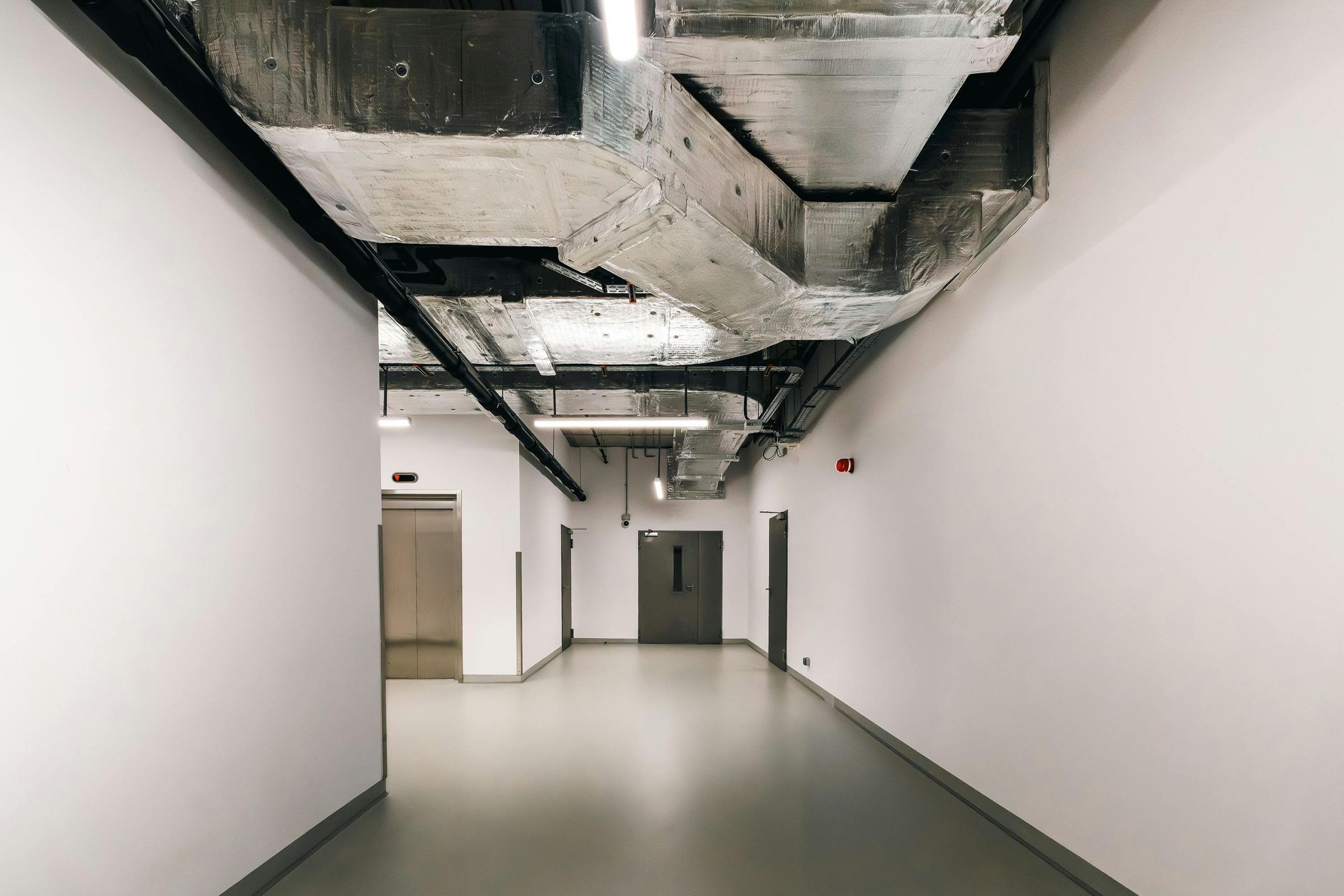 pexels photo 30749458 30749458 Spacious industrial hallway featuring exposed HVAC ductwork and modern design elements.